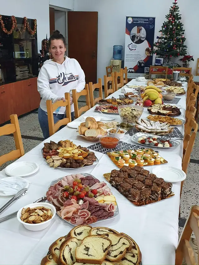 Bufet interior cu sandvisuri, salate si prajituri, pe o masa lunga