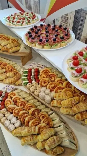 Bufet cu patiserie, canapele si mini rulouri, pe platouri albe