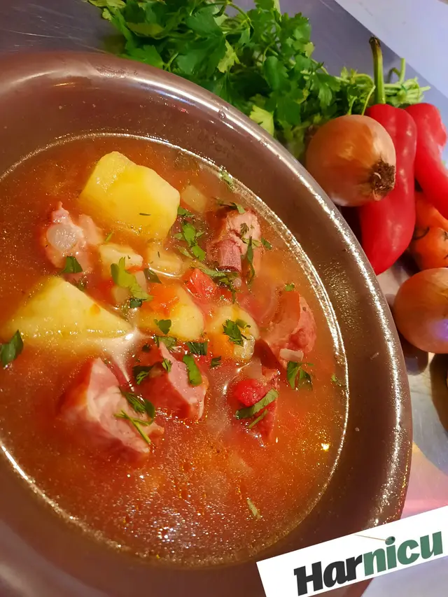 Ciorba servita in vas de lut, cu legume proaspete alaturi