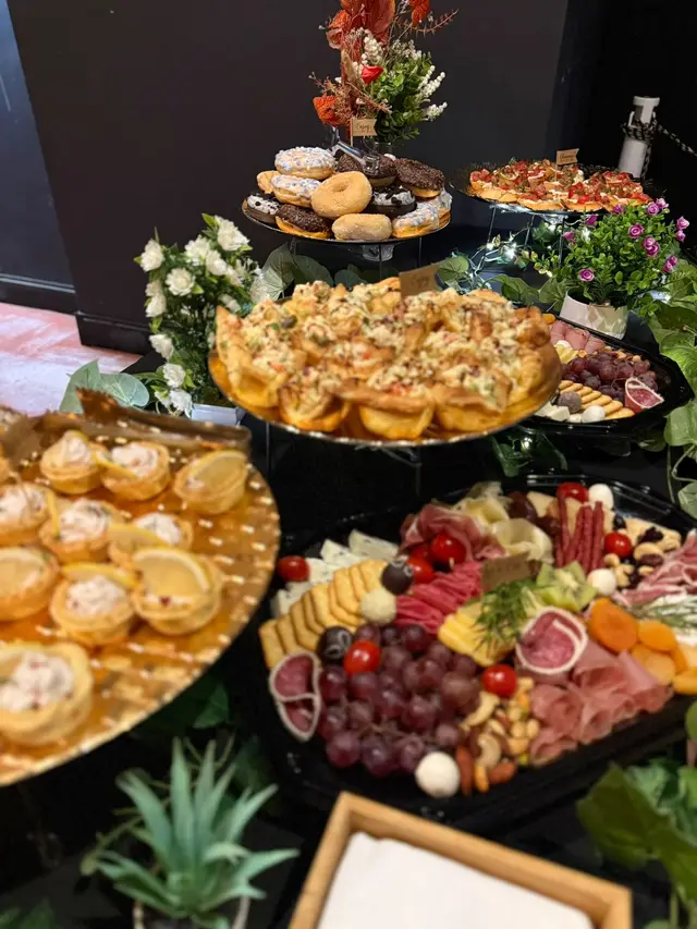 Turn de tartelete si platou de antreuri, decorate cu flori albe, la un eveniment Harnicu