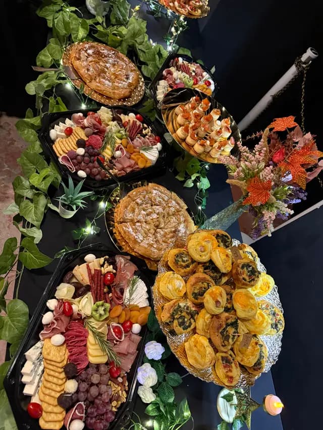 Platouri cu mezeluri si tarte savuroase, asezate in decor floral