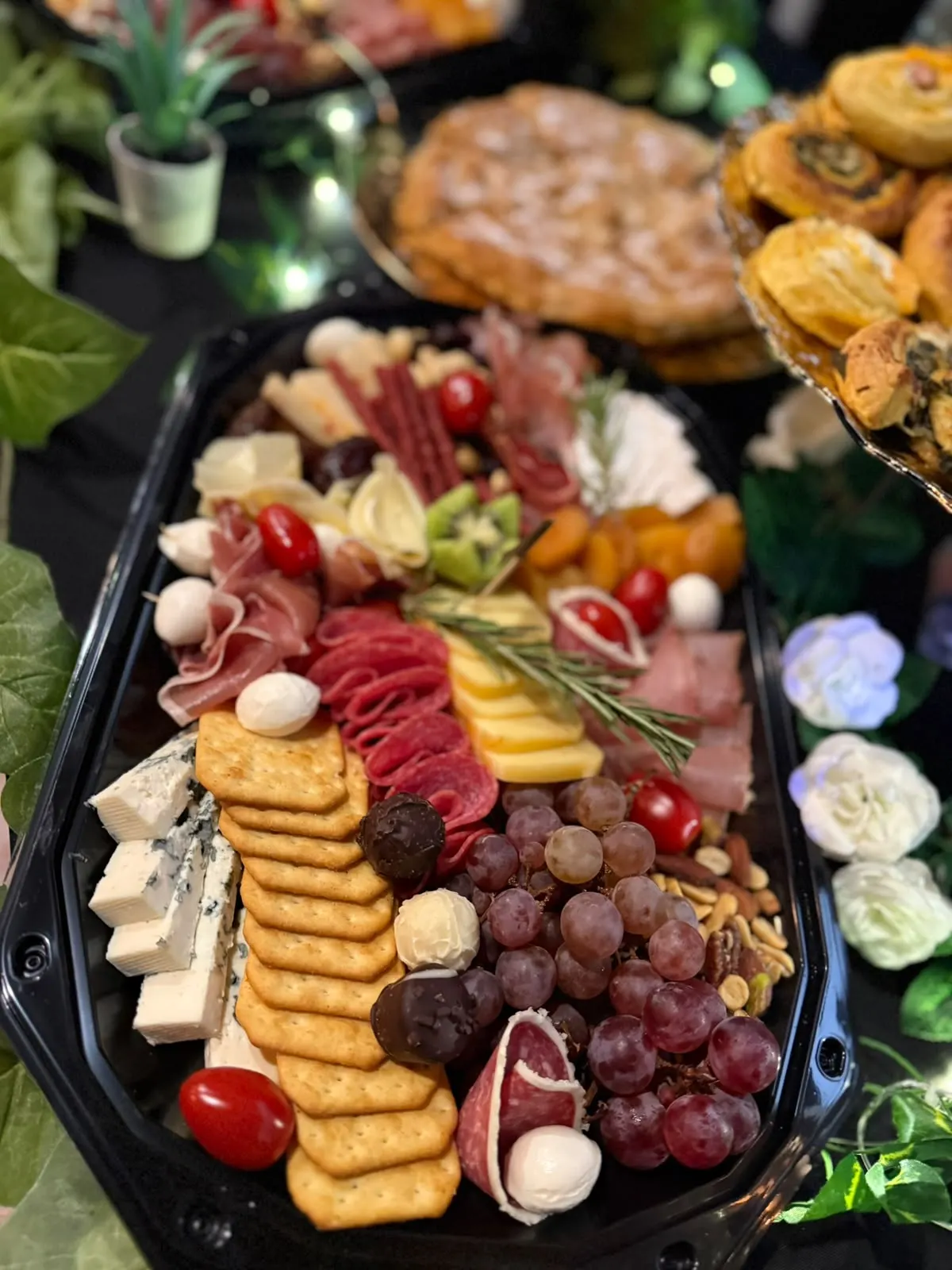 Detaliu de platou charcuterie: salam, prosciutto, branzeturi si struguri