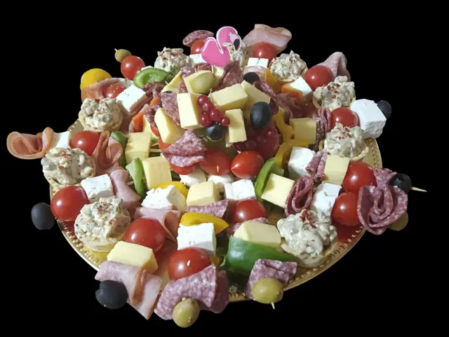 Platou de charcuterie cu mezeluri, branzeturi, masline si rosii cherry, pe fundal negru